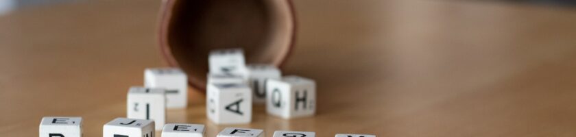 a wooden table topped with dices and letters